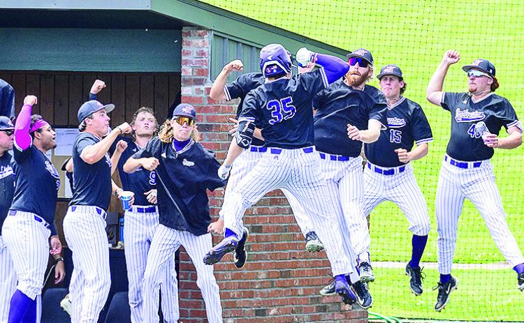 Colin Rains (35) is greeted by teammates, including pitcher Josh Miller (facing, jumping), following a three-run home run Monday. Photo by Chris Reich/NSU Photographic Services