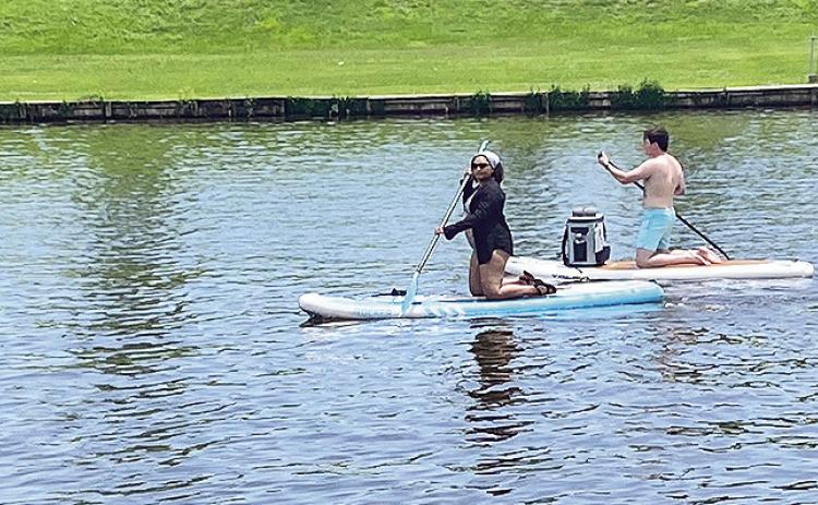 Two people explore Cane River Lake along the downtown Riverbank Saturday atop a paddle board. Over the years paddle boarding has continued to grow in popularity as it offers a full body core workout while experiencing the beauty of the outdoors.