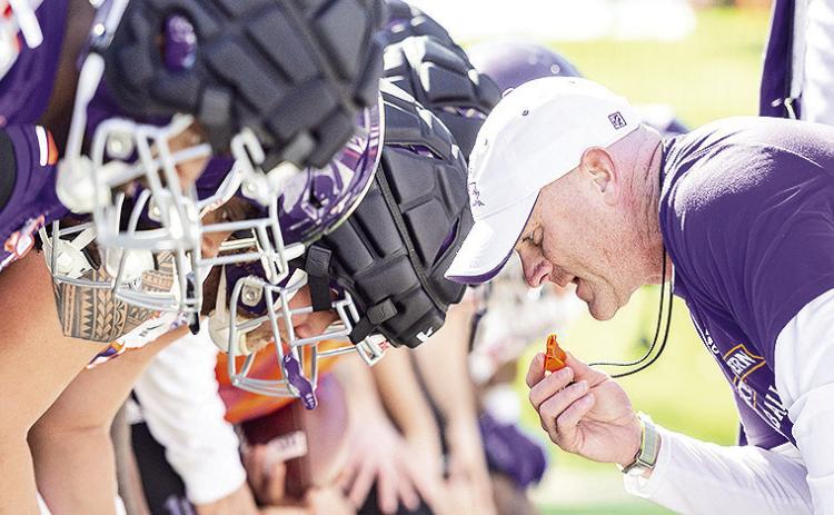 Head coach Blaine McCorkle leans toward his team to start a drill Monday. Photo by Chris Reich/NSU Photographic Services