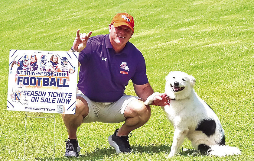 Northwestern State head coach Blaine McCorkle poses with a fan's dog during the 2025 season-ticket delivery day this past July. Credit: NSU Athletics