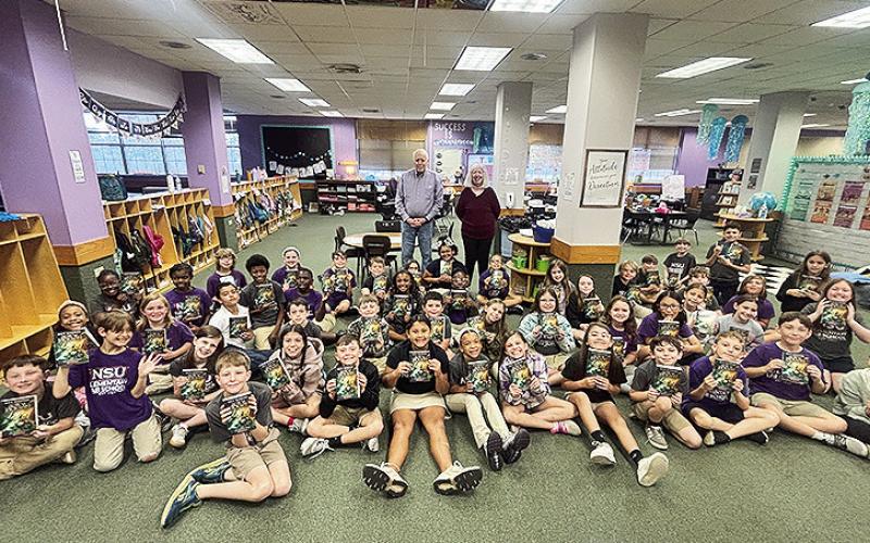 Ron McBride and Barb Duchardt gave books to NSU E-Lab 4th graders.