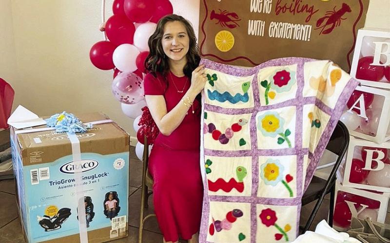 Amanda Weeks holds baby quilt given to her by the Old Bethel Sewing ladies Saturday.