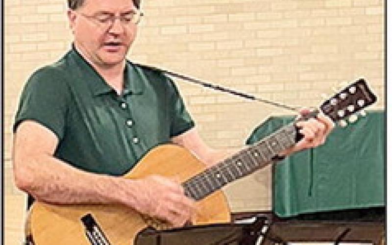Dr. Sam Stokes sang and played traditional folk songs for the group.
