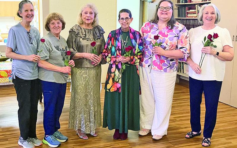 Receiving red roses were, from left, Mary Squyres, Susan Massia, Dianne Alexander, Gilen Norwood, Donna Baker and Janine Storrs after the installation of officers.