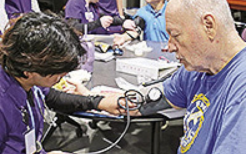 NSU nursing student Ruben Kho of Alexandria checked Don Barker’s blood pressure following a Demons Engage presentation for the Kiwanis Club on March 12.