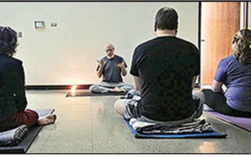 Richard Rodgers welcomes the participants to the first yoga class of the NPL’s Fitness Series.