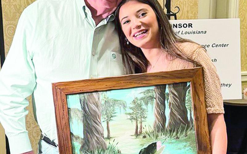 Florien High School Talented Art Student Aubree Leach is shown with her original painting “Bayou Bass” with the successful bidder Harlan Leach of Florien.