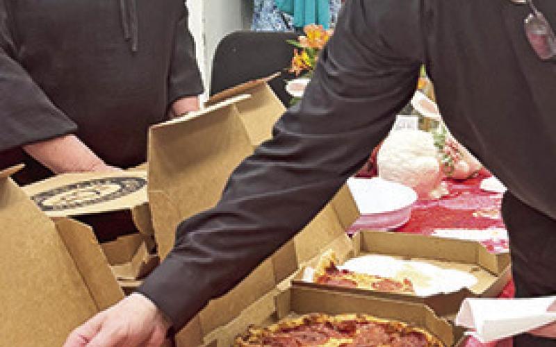 Music Director and Conductor Doug Bakenhus tries a piece of pizza.