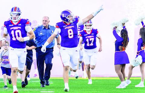 Luke Carter, #9, leads the team onto the field during pregame ceremony. Credit: Chris Reich, NSU Photographic Services