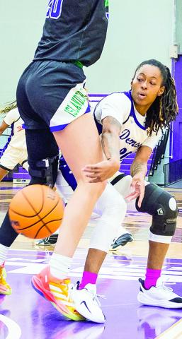 Tiara Abron (right) passes a ball around the defender near the basket. Photo by Chris Reich, NSU Photographic Services