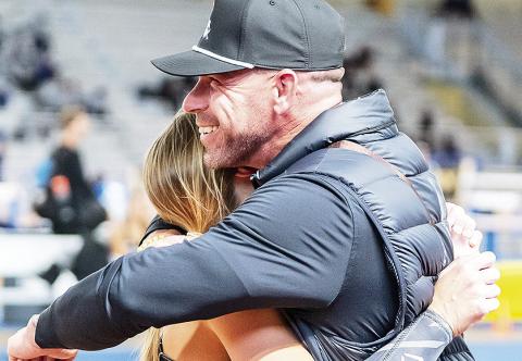 Adam Pennington (right) is hugging pole vaulter Madison Brown during the Southland Conference Indoor Championships earlier this month
