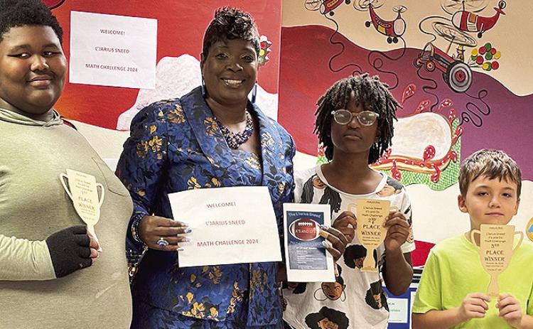 From left are John Taylor, first place winner; Jane Sneed (Sneed's mother) Symone Jackson, second place winner; and Kolbe Darbonne, third place winner. Taylor is a student at East Natchitoches Elementary School and Jackson and Darbonne are Natchitoches Magnet School students. The students received a wooden trophy designed plaques-donated by the industrial engineering technology department at Northwestern. In December, they will be honored with a pizza and sweets party.