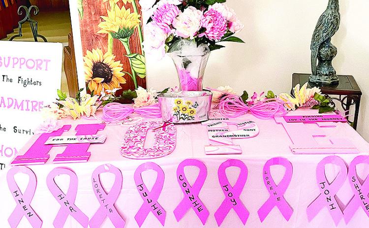 of Breast Cancer Awareness Month. Each of the ribbons has the name of a breast cancer fighter from the church or a family member written on it.