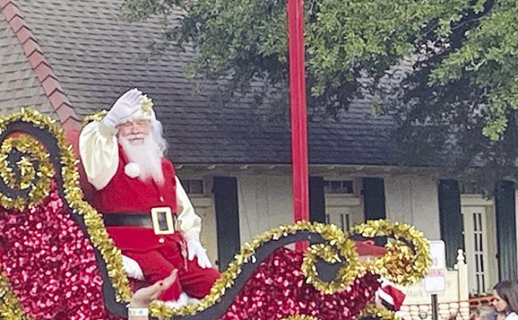 Santa Claus waved to the delight of thousands who witnessed the Christmas Festival Parade Saturday. Photo by Nora Drenner