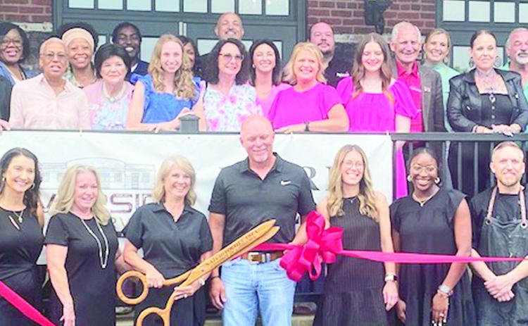 Scores turned out for the celebration and ribbon cutting commemorating the grand opening of Riverside Reserve on Mill St. Among the attendees were Mayor Ronnie Williams, Jr., Councilwoman-at Large Betty Sawyer Smith, Councilman Dale Nielson, Parish Councilman Wayne Halma, and Chief of Police Nikeo Collins. Pictured in front with scissors and ribbon are owners Kelly and Lynn Foreman Dorton surrounded by staff.