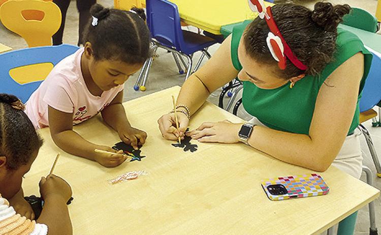 Kacy Young of Cane River National Heritage Area decorates Christmas tree crafts with Rielle W. and Nova W. for Christmas in July as part of the NPL’s Sprout program.