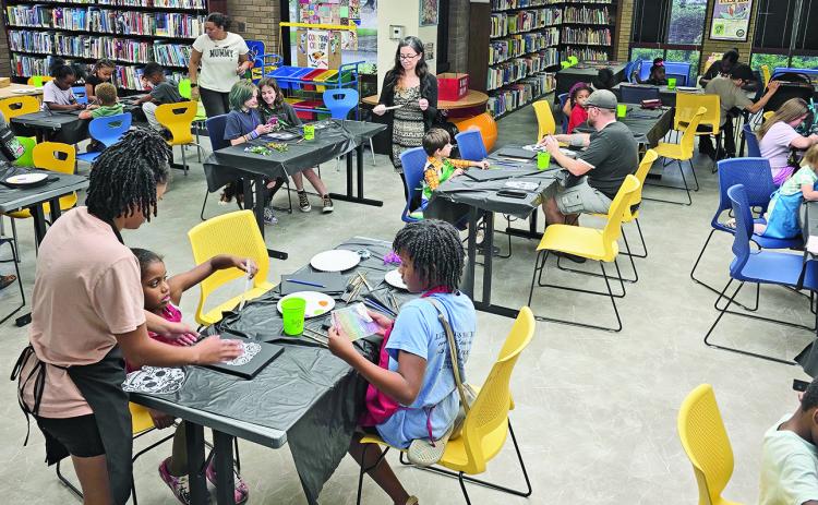 Families create mixed-media calavera paintings together during the Natchitoches Parish Library’s Fall Family Night in the Children’s Department Oct. 5. Numerous other activities are planned for throughout October.
