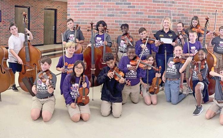 The Krewe of Dionysos annually donates to organizations in the community. This year, Captain Brandi McManus presented a check to the NSU Middle Lab Orchestra.