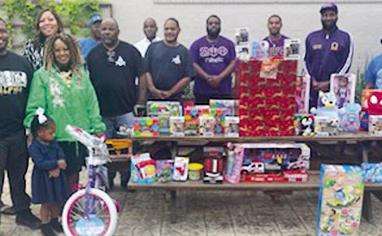 Members of the Krewe of Nine who are conducting a Christmas toy drive are, from left, Sylvester “Sly” Moss, Ruby Braxton, Dr. CarDarrius Murphy and daughter, Betty Sawyer Smith, Clarissa Davis (behind Smith), Robert Murphy, Sam Chism, Jim Murphy, Eugene Wheeler, Jalen Sturgis, Carlton Johnson II, Ronnie Bennett, Michael Wilson and Shirley Bennett.