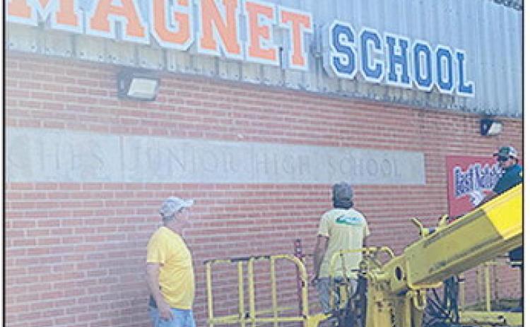 Workers erect a new sign for the Natchitoches Magnet School that moves to a new location, in the former East Natchitoches Elementary School on East Fifth Street.