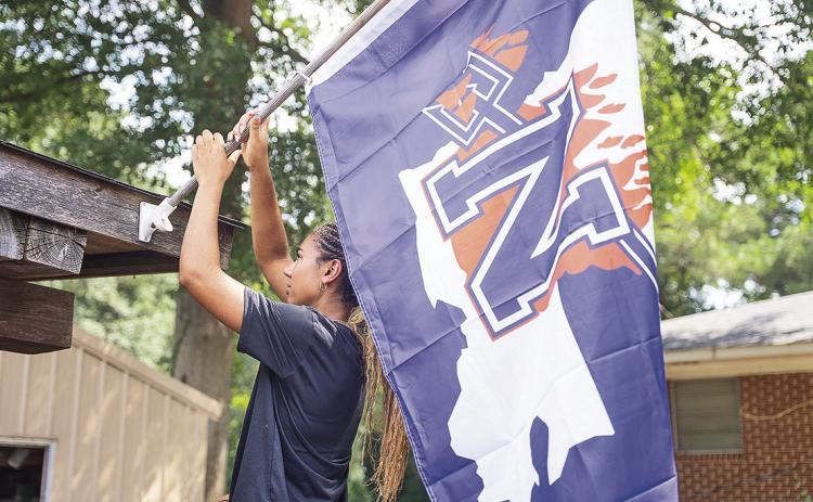 NSU Junior Makenna Tryon, a Lady Demon volleyball player from Waller, Texas, joined fellow student volunteers in distributing NSU flags and signage to Natchitoches homes and businesses July 30. If you would like some Demon swag for your home or office, visit www.nsu.la/purple.