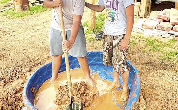 Trey Roque and Jason Hull have mastered the art of “making mud walls” as part of the Badin Roque Park project. Trey is the greatgreat grandson of Edward “Wood” Antee who sold the historic house of late 1700’s to St. Augustine Historical Society in 1979. The house served as the first convent and Catholic school for parishioners of Saint Augustine Catholic Church. Courtesy photo by SAHS President Mark Guidry.