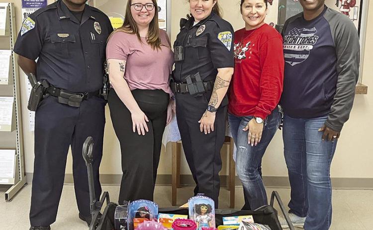 Officers with the Natchitoches Police Department recently delivered Christmas gifts to the Department of Children and Family Services to be distributed to foster children and to families in need during this holiday season. Pictured from left are Officer Joshua Wolf, Officer Summer Carter and Lieutenant Jessica Williams.
