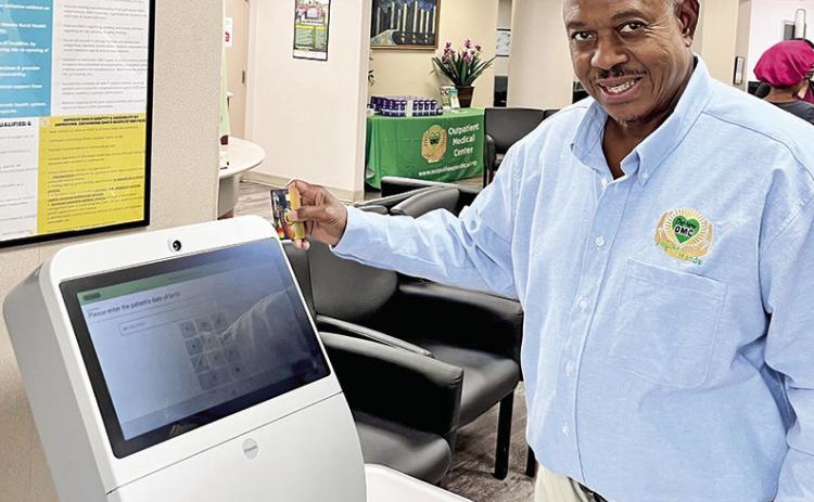 OMC Board Member Rev. Ronnie Evans shows the new check-in kiosk.