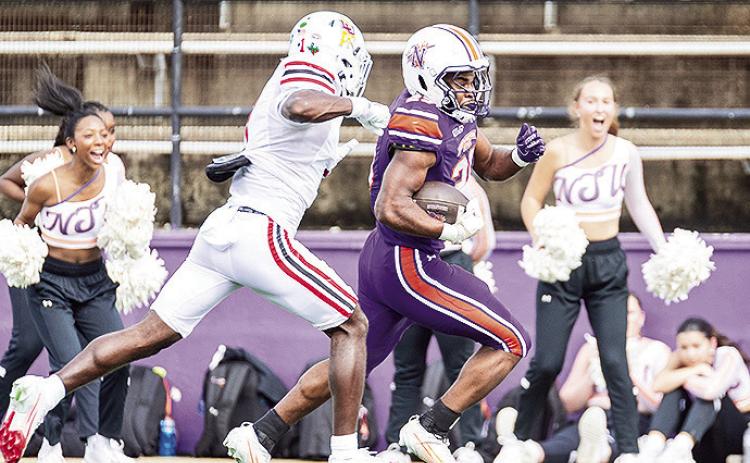 Jeremiah James (purple) rushes towards the end zone on one of NSU’s eight explosive plays as Lamar’s Kristian Pugh (white) gives chase. Photo by Chris Reich, NSU Photographic Services