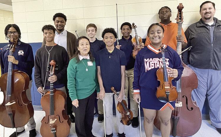 Syll Young-Olson and seven of her string’s music talent students auditioned for the All-State Orchestra and all seven were selected to be a part of the Louisiana Middle School All-State Orchestra. From left on front row are Ukpai, Ryland Snow, Olson, Nicholas Washington and Peyton Helaire. On back row row are Principal Antavious Roberson, Everett Watson, Robert William, Boss LaCase, and Orchestra Director Evan Korn.