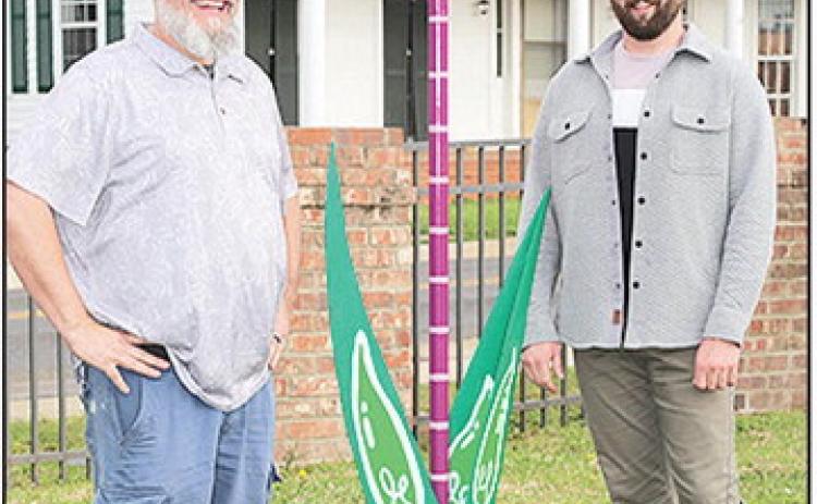 Cohver, at left, and McManus stand with the 8 ft Tulip sculpture unveiled in the courtyard outside the BOM Financial offices.