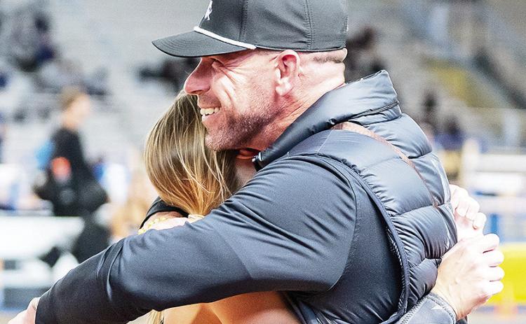 Adam Pennington (right) is hugging pole vaulter Madison Brown during the Southland Conference Indoor Championships earlier this month