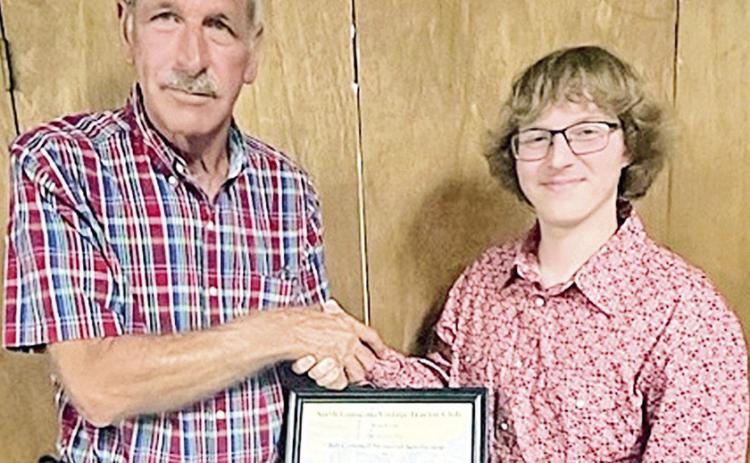North LA Vintage Tractor Club president Barry Howard congratulates scholarship winner Joseph Wheelus of Ruston.