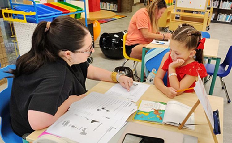 Avery Krocker receives help with homework in the NPL Children’s Department, available to the public for free through a library partnership with Northwestern State University.