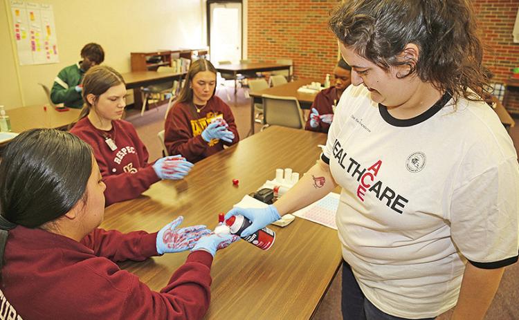 NSU Assistant Professor of Nursing Kelli Sutton led a demonstration on glove safety for Natchitoches Central students Caroline Balthazar, Sarah Marbut, Kamryn Dawson and Cheyenne Hooper during the ACE healthcare exploration program May 10. About 40 students from NCHS and Lakeview High School attended the program that focused on healthcare academics and careers.