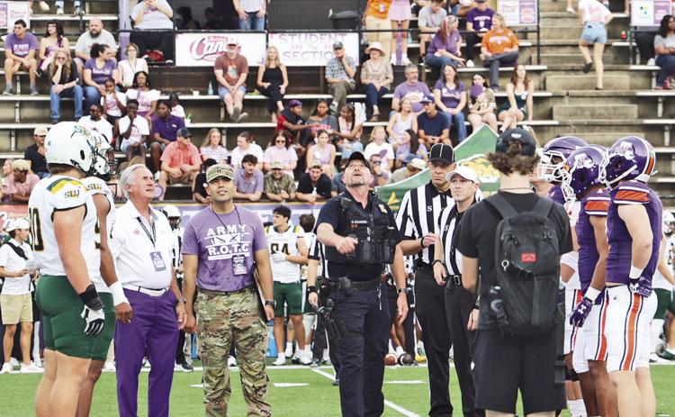 Staff Sergeant (Ssgt.) Retired, Donterry Colombel, center, did the coin toss prior to NSU’s football game against Southeastern Sept. 26. In addition to players and game officials, he was accompanied by NSU President James Genovese and Capt. Armando Lopez, head of NSU’s Department of Military Science.