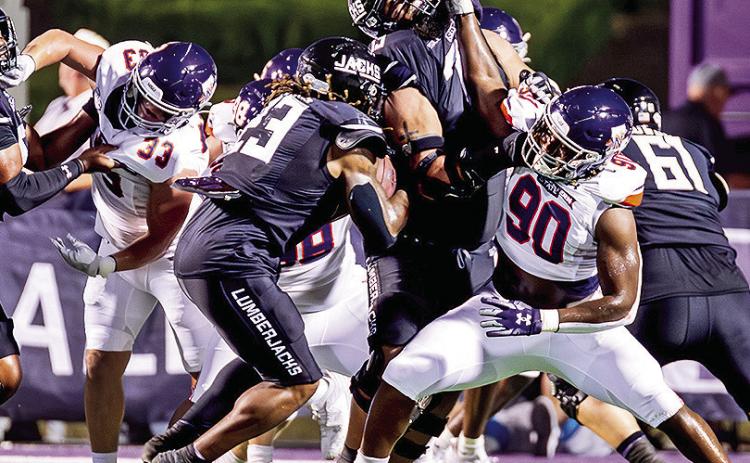 Chancellor Owens (90) fends off the SFA offensive line Saturday night. Photo by Chris Reich/NSU Photographic Services