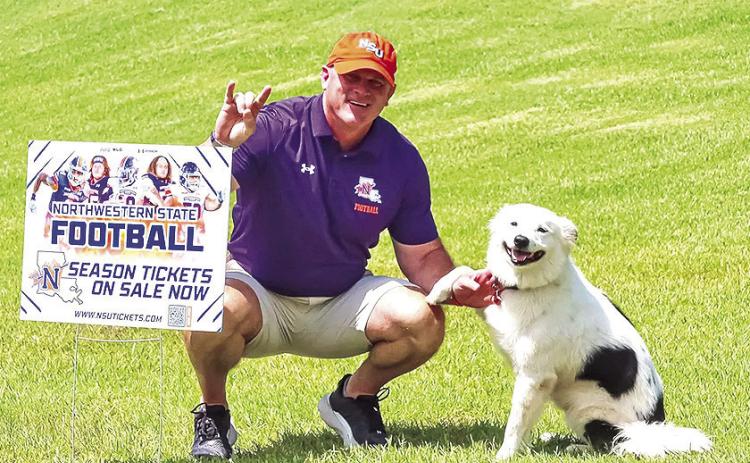 Northwestern State head coach Blaine McCorkle poses with a fan's dog during the 2025 season-ticket delivery day this past July. Credit: NSU Athletics