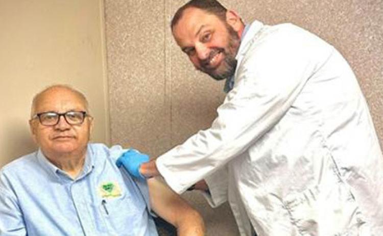 Christopher Guy, DON, gives a flue shot to OMC Board President Tommy Roque.