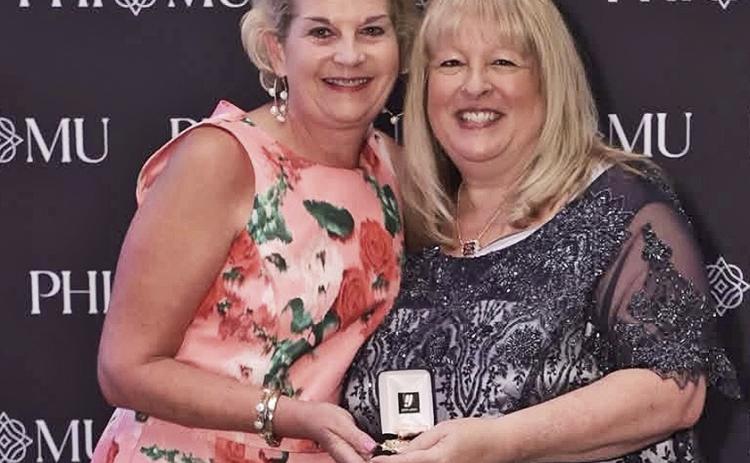 NSU alumna Emilyn Matthews Horton, left, received Phi Mu Fraternity’s Outstanding Alumna Achievement Award for Contribution to the Community at the organization’s 2026 National Convention in Atlanta. The award is presented to one alumna every two years from Phi Mu’s worldwide membership of more than 200,000 women. Lynn Storlien McGraw, national president of Phi Mu, presented the award.