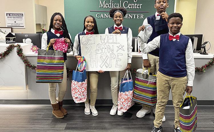 Natchitoches Jr. High JAG members deliver scarves and beanies to Natchitoches Regional Medical Center - Cancer Center patients during Breast Cancer Awareness Month. From left are MyCayah Roberson, Genesis Conday, Mariah Holliman, DaMykael Castle, Jermaine Williams, Lakayla Jones, Myliah Bayonne and Dominic Cross.