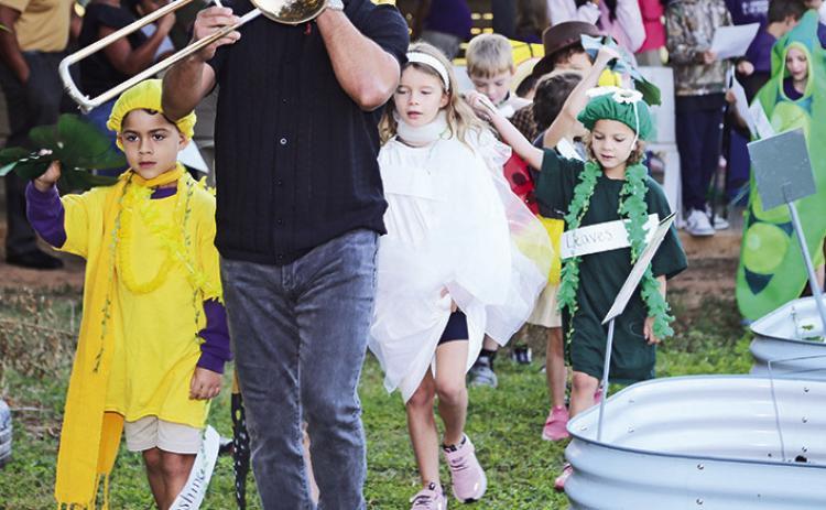 Gabriel Camargo Patron, with his dad Carlos on trombone, led NSU Elementary Lab first graders in a second line through the school garden to the tune of “When the Seeds Get Planted Snug.”