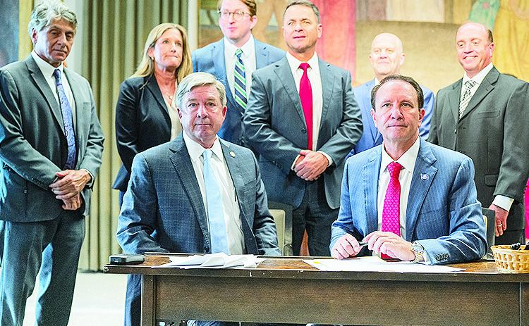 Natchitoches Parish District Attorney Billy Joe Harrington, seated left, joined Gov. Jeff Landry as he signed a bill that addresses domestic violence offenses.
