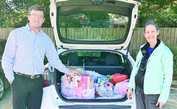 Donovan Ohnoutka, president of the Jaycees, received a large number of gifts from Lesche Club member Mary Squyres for “Make A Smile Happen.”