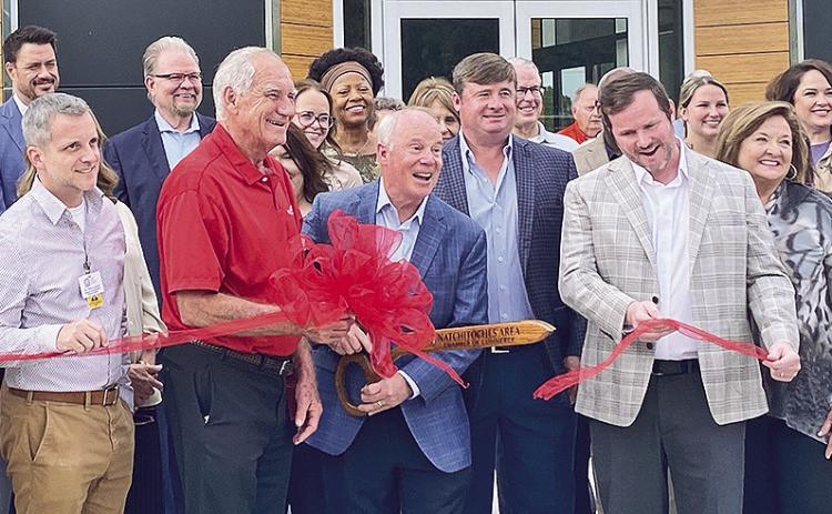 Mark Hebert, CEO of Hebert Jeep Chrysler Dodge Ram cut the ribbon Wednesday to celebrate the opening of its new location. Natchitoches Area Chamber of Commerce Director of Development Dustin Dauzant extended congratulations and touted the large turnout. Pictured in the front row from left are Dr. Thorn LaCaze, Director of Bossier Parish Community College Natchitoches and Sabine campuses; District Three Parish Councilman elect Wayne Halm, Mark Hebert, sons Beau and Chris, and wife Floy. Photo by Nora Drenner