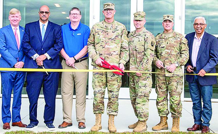 Maj. Gen. Keith Waddell, the adjutant general of the Louisiana National Guard, Col. Scott Slaven, the construction facilities management officer, Command Sgt. Maj. Clifford Ockman, the LANG’s senior enlisted leader, and key LANG, State, and local leaders pose with scissors during a ribbon cutting ceremony to celebrate the completion of the Training Center Pineville Readiness Center in Pineville.