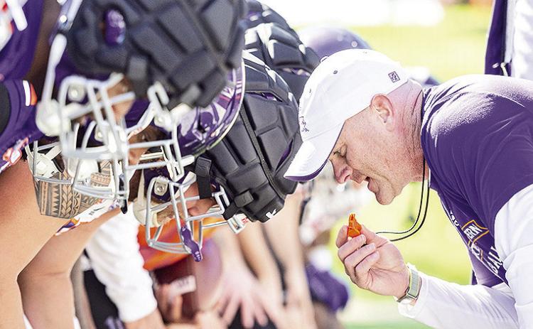 Head coach Blaine McCorkle leans toward his team to start a drill Monday. Photo by Chris Reich/NSU Photographic Services
