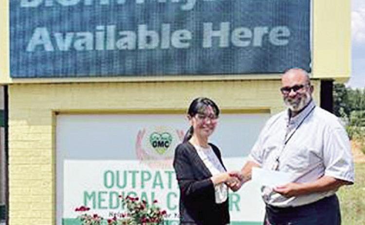 CEO Dr. Mark Guidry presents Kazue Seo the Employee of the Month award.
