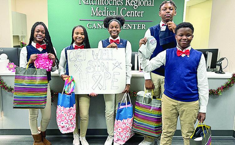 Natchitoches Junior High JAG members deliver scarves and beanies to Natchitoches Regional Medical Center - Cancer Center patients during Breast Cancer Awareness Month. Pictured from the left are MyCayah Roberson, Genesis Conday, Mariah Holliman, DaMykael Castle, Jermaine Williams, Lakayla Jones, Myliah Bayonne and Dominic Cross.