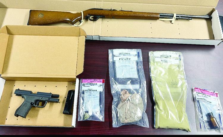 Rifle, handgun and narcotics are seized.